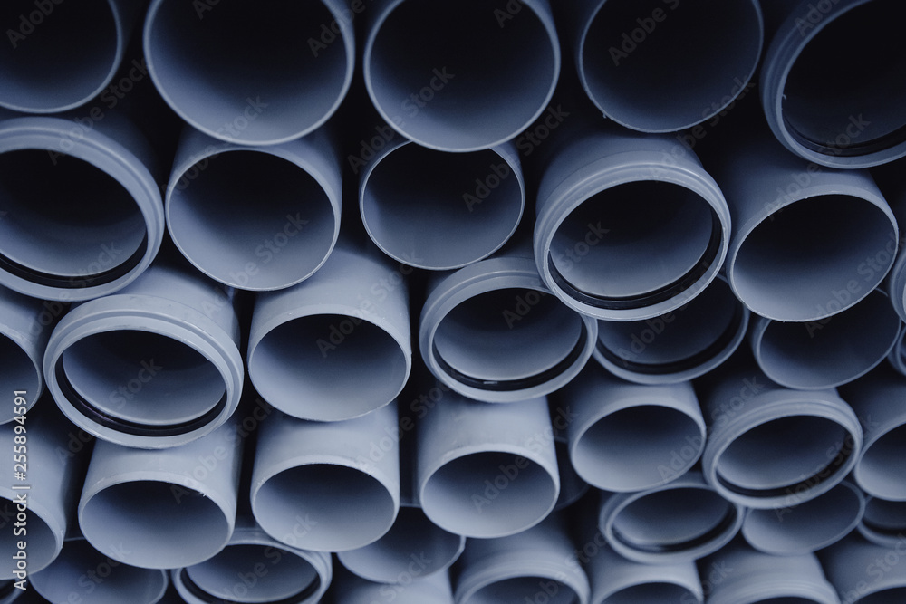 PVC plastic construction pipes for water are displayed in row on counter