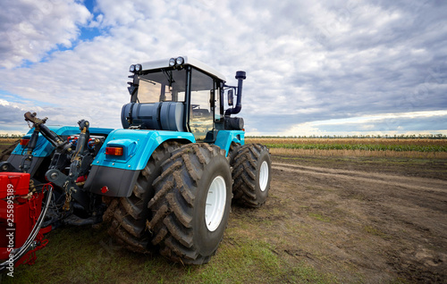 Tractor working in a field against a cloudy sky