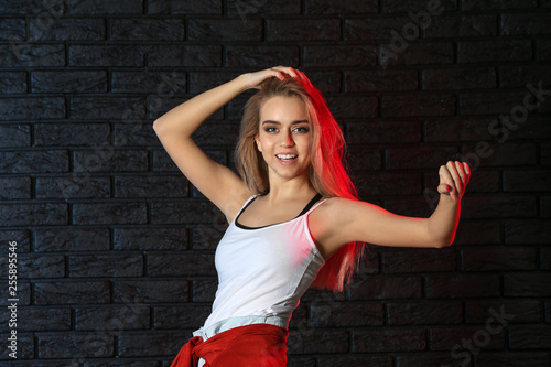 Young female dancer on dark background