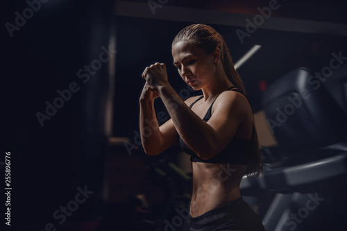 Fighter girl boxer punches pear fist, hair in motion. Fitness concept