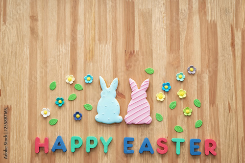 Tasty cookies with text HAPPY EASTER on wooden table