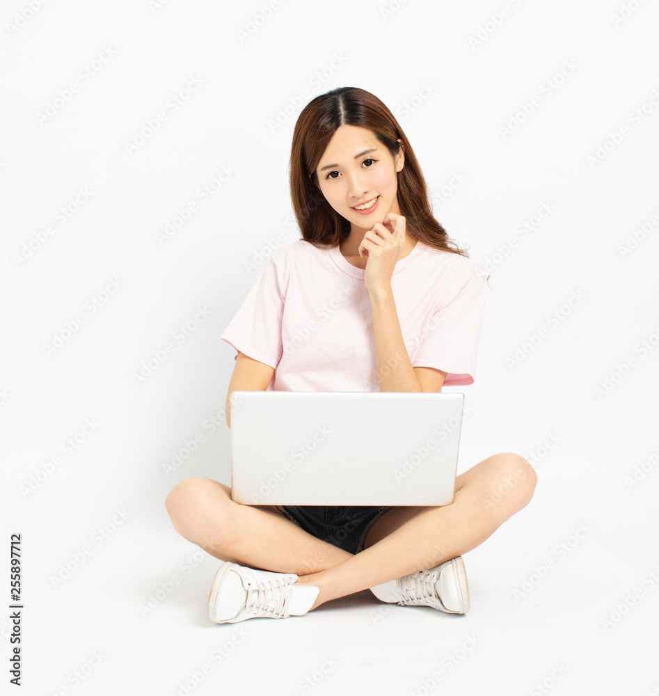 Happy young woman sitting on the floor using laptop Happy young woman sitting on the floor using laptop