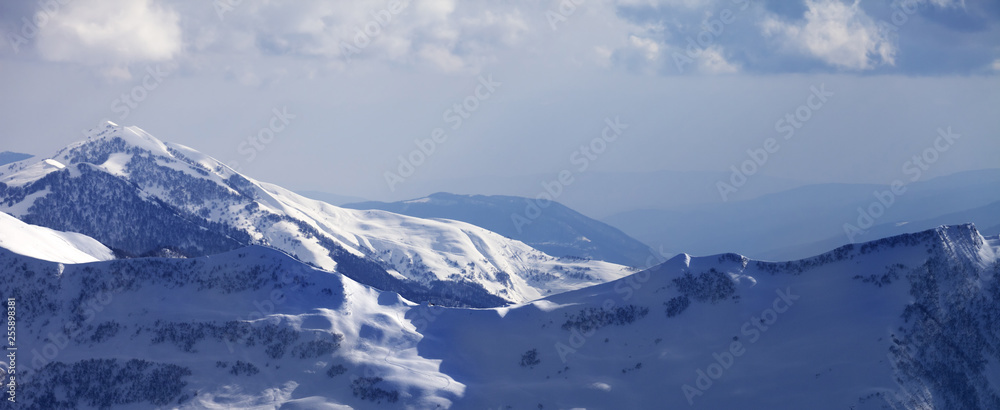 Panoramic view on snowy off-piste slope at winter evening