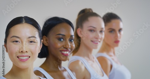 Portrait of women of different ethnicities with beautiful faces and perfect skin just cleaned from impurities ready for day or night cream are smiling in camera.
