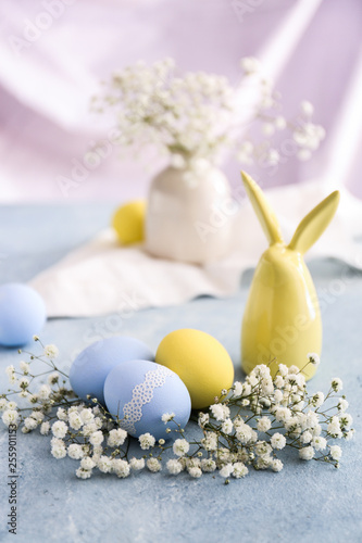 Easter eggs with flowers on color table