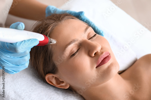 Young woman undergoing procedure of bb glow treatment in beauty salon photo