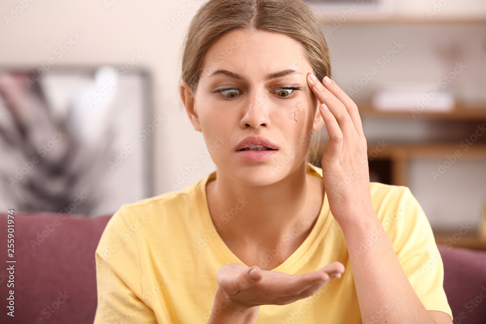 Stressed woman with eyelash loss problem at home Stressed woman with eyelash loss problem at home