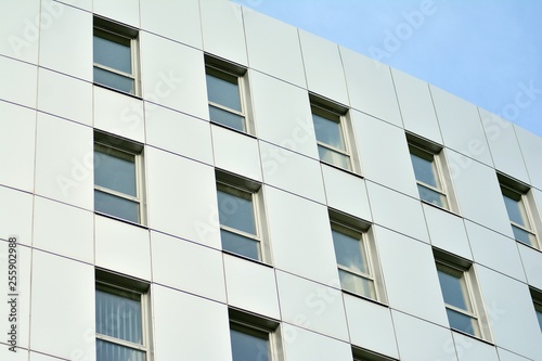 New office building in business center. Wall made of steel and glass with blue sky. 