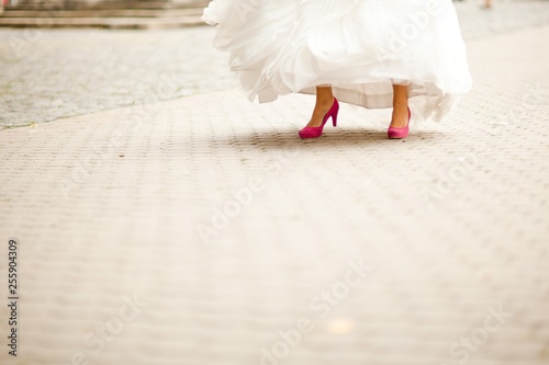 Bride shoving her purple wedding shoes - Street moment. photo