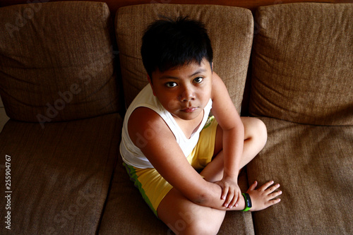 Young Asian boy sitting on a couch