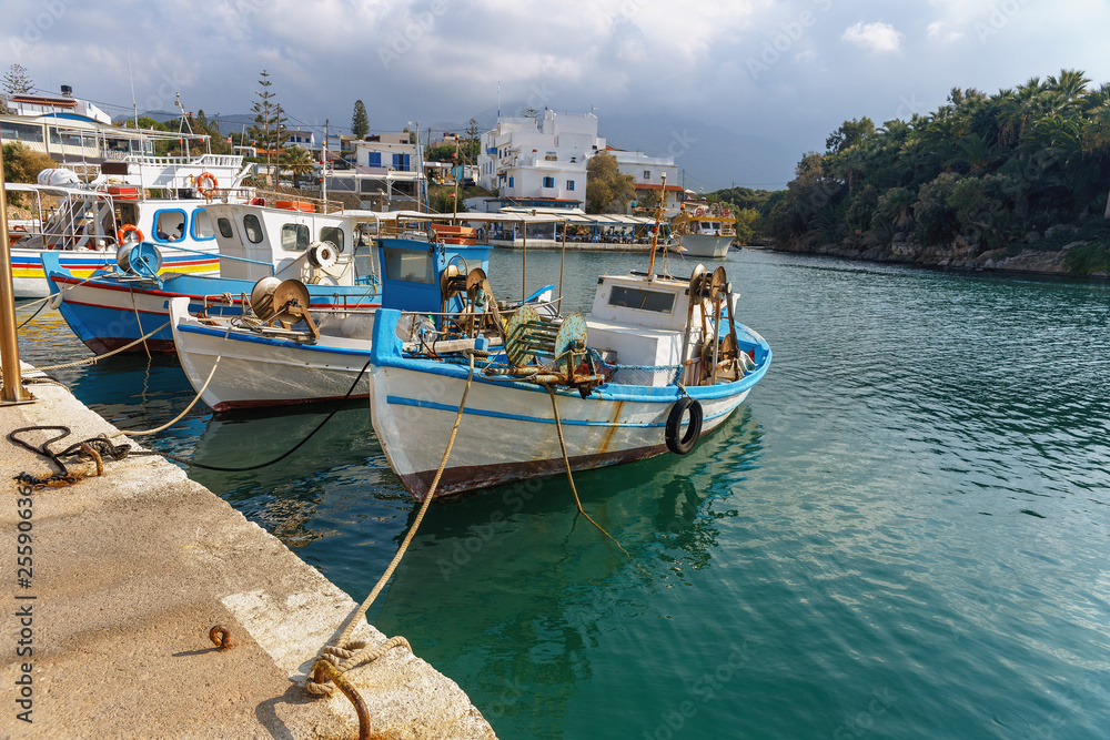 view of small fishing boats in a quiet harbor in the greek village of Sissi