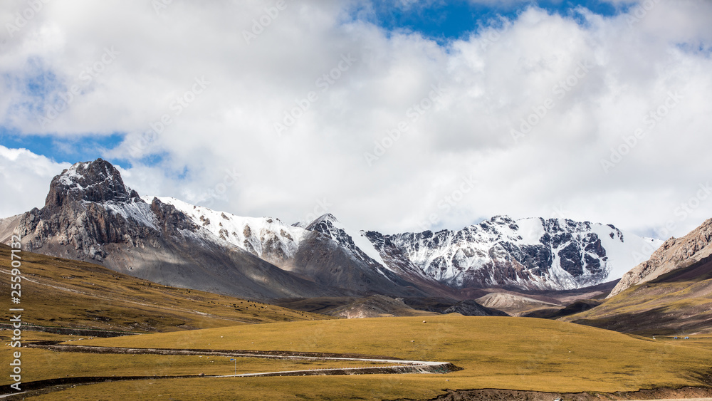 Fototapeta premium Nature landscape of snow mountains under clear blue sky with clouds