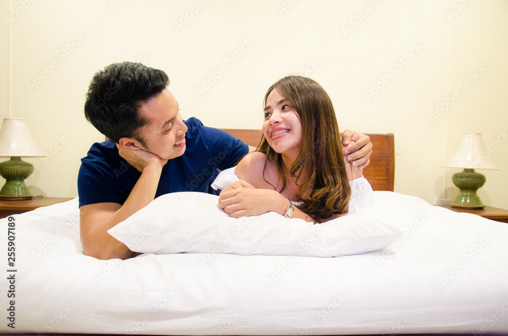 asian couple lying on bed ,eye contact together asian couple lying on bed ,eye contact together