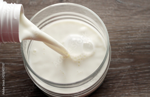 Pouring fresh milk into a glass bowl