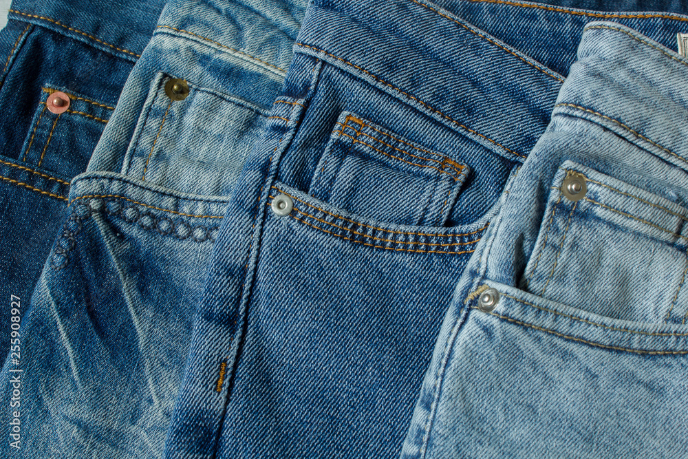 New denim pants clothes pile background. Stack of blue jeans different shadows New denim pants clothes pile background. Stack of blue jeans different shadows