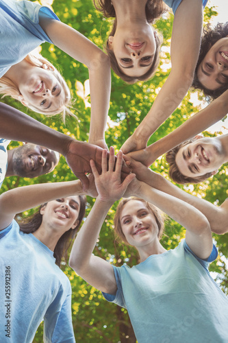 Group of happy volunteers collaborate at park