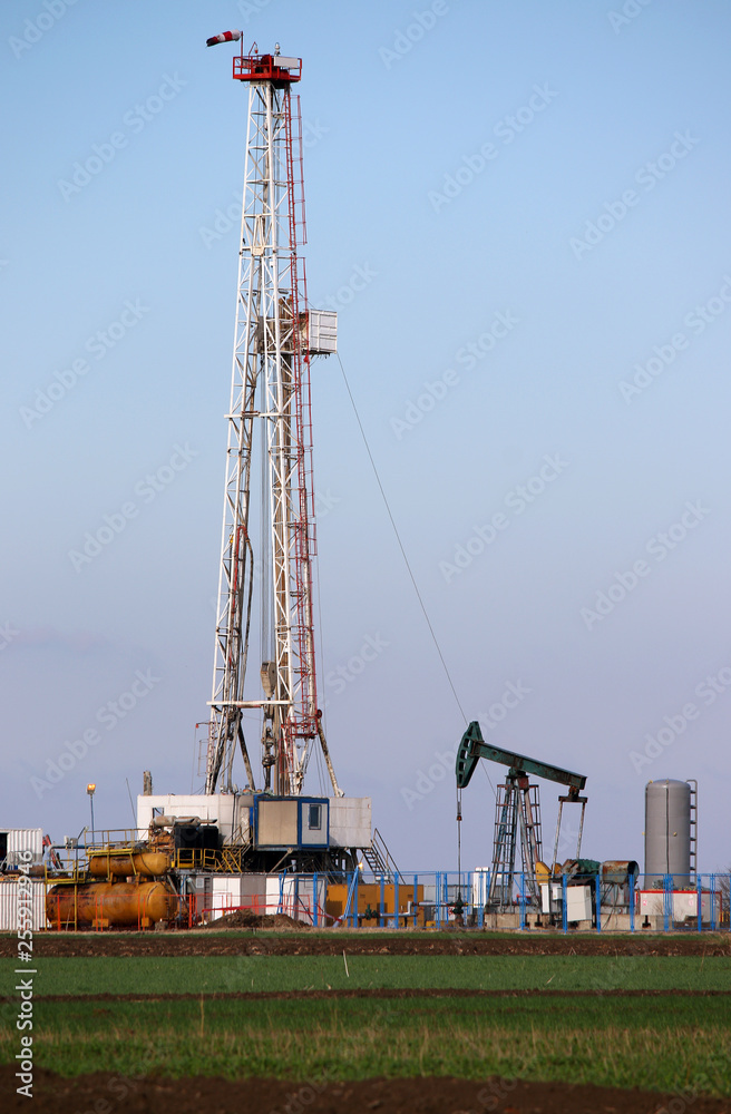 Oil and gas drilling rig and pump jack in oilfield Oil and gas drilling rig and pump jack in oilfield