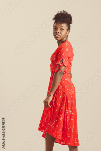 black woman looking challenging with red flowered dress