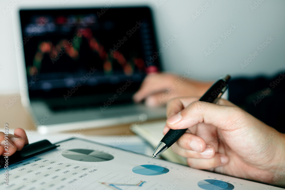 Two investors work together and note the stock price to compare with other stocks. Two investors work together and note the stock price to compare with other stocks.