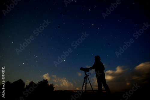 Silhouette of an adult man with a telescope