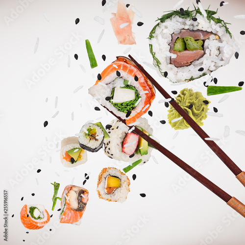 Pieces of delicious japanese sushi frozen in the air. Isolated on light grey background