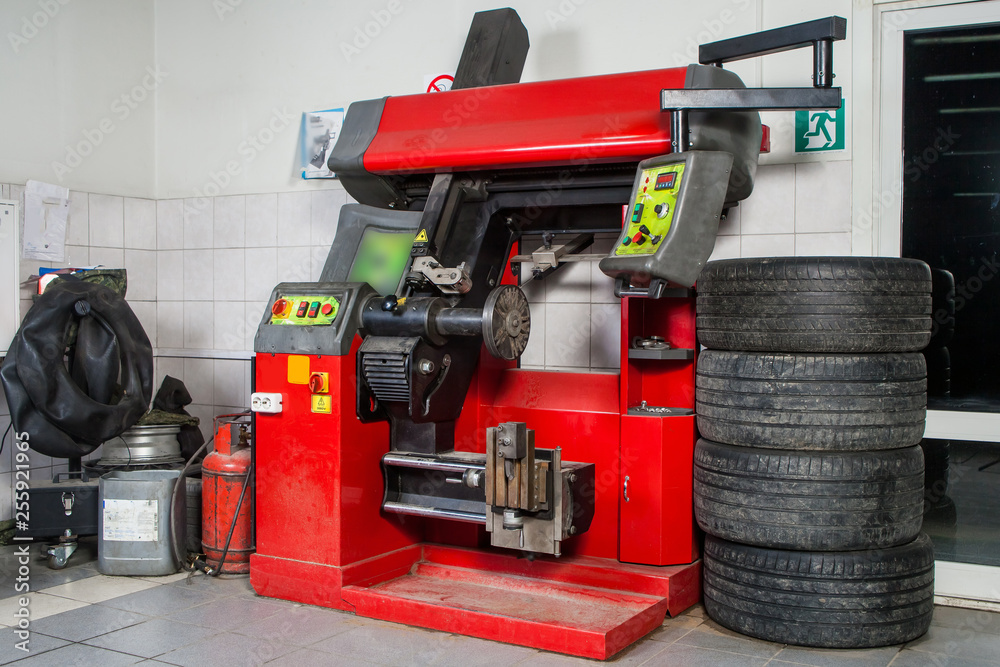 Fototapeta premium A close-up of the modern tire changer for repairing and repairing alloy wheels stands against the backdrop of a workshop for car repair and tire mounting.The concept of the tire workshop
