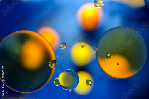 orange and yellow balls on a blue background of oil stains