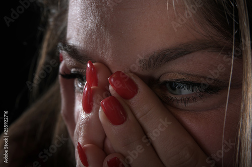 Frau schaut verzweifelt ängstlich mit vorgehaltener Hand vor dem Mund photo