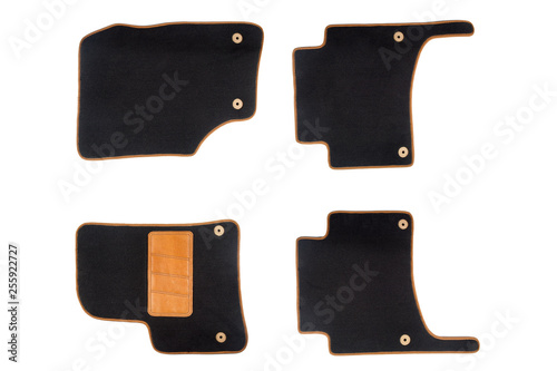 Black-brown floor mats of carpet, velor for the front and rear seats of the car on a white isolated background, top view.