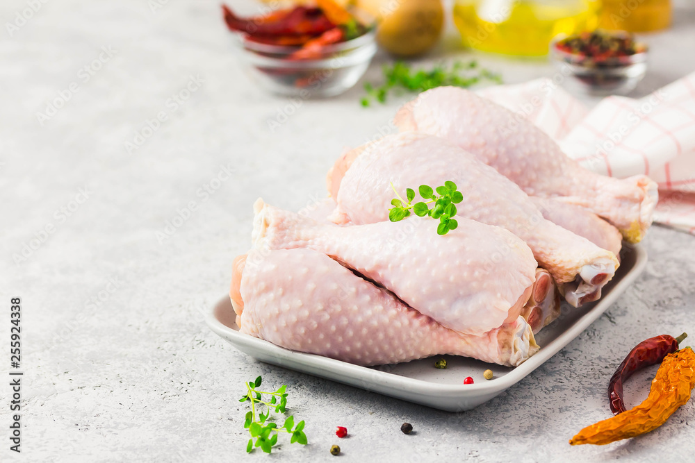Raw chicken legs,spices and olive oil on concrete background. Top view, space for text. Raw chicken legs,spices and olive oil on concrete background. Top view, space for text.