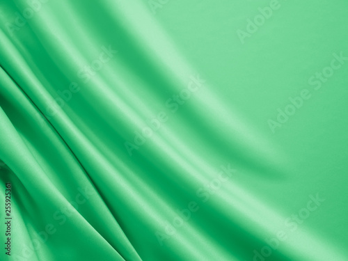 Beautiful smooth elegant wavy light green satin silk luxury cloth fabric texture, abstract background design. Card or banner.