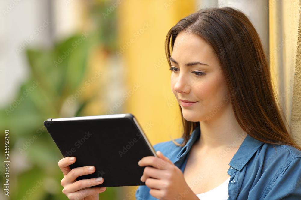 Serious woman watching media on tablet in the street Serious woman watching media on tablet in the street