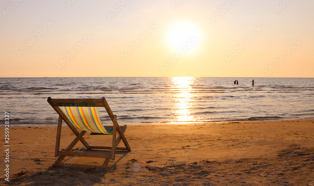 Beach chair on the tropical beach at sunset time