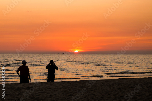silhouette of two men talking at sunset time