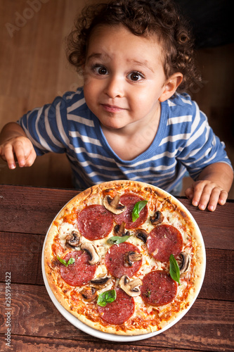 Boy ready to eat a pepperoni pizza