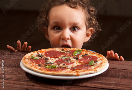 Boy ready to eat a pepperoni pizza