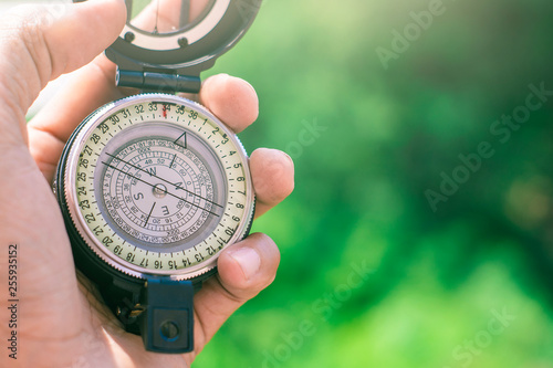 holding compass on blurred background. Using wallpaper or background travel or navigator image.