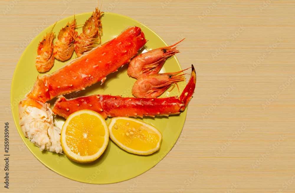 boiled king crab, shrimps in a plate on a wooden background