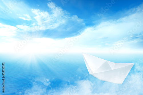 White paper boat sailing on blue ocean