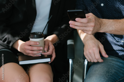 Business colleagues. Break from work. Man with smartphone. Woman with coffee on notepad.