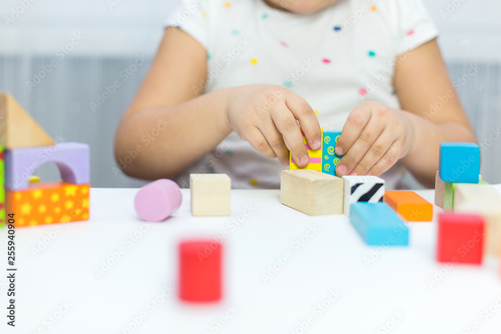 Children play with educational toy on table in the children's room. Two kids playing with colorful blocks. Kindergarten educational games Children play with educational toy on table in the children's room. Two kids playing with colorful blocks. Kindergarten educational games