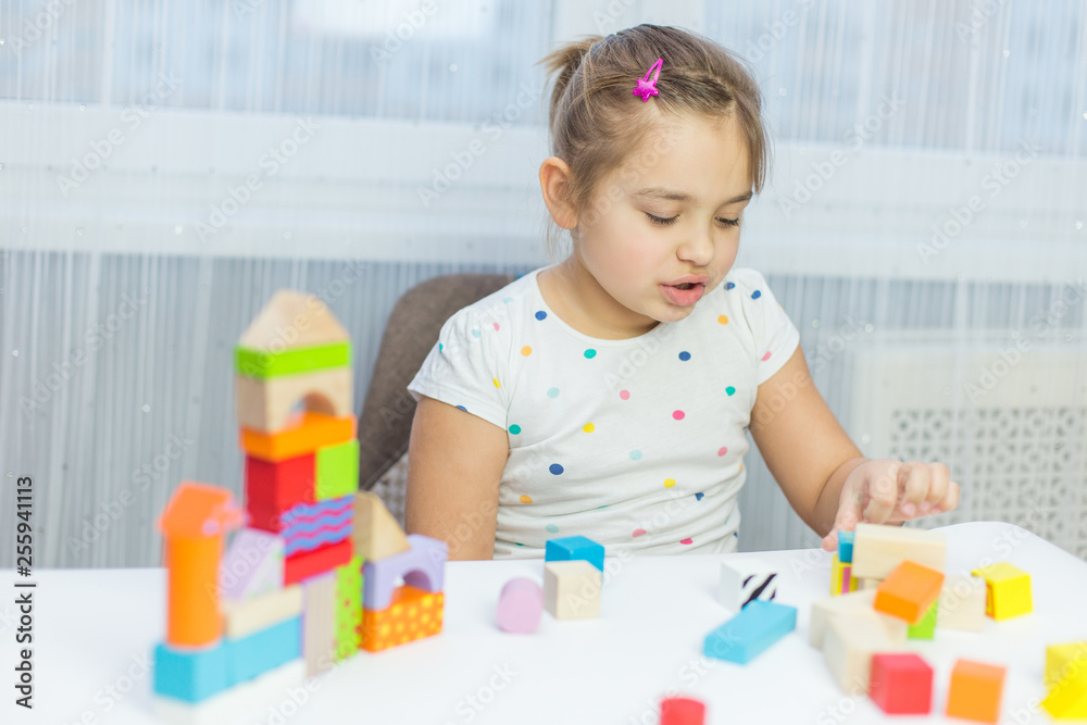 Children play with educational toy on table in the children's room. Two kids playing with colorful blocks. Kindergarten educational games Children play with educational toy on table in the children's room. Two kids playing with colorful blocks. Kindergarten educational games