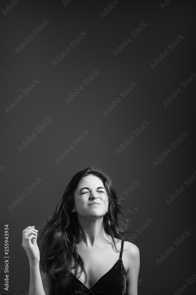 Woman desire and aspiration. Young female with eyes closed wishing for good luck. Black and white. Copy space. Woman desire and aspiration. Young female with eyes closed wishing for good luck. Black and white. Copy space.