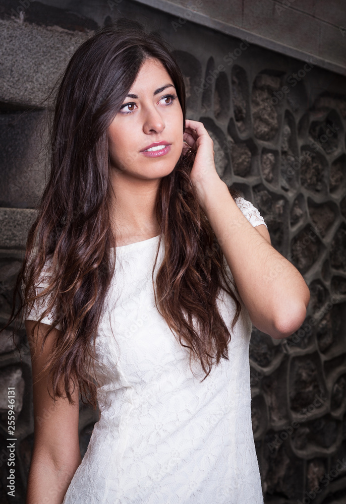 Fototapeta premium pretty brunette girl with brick wall background