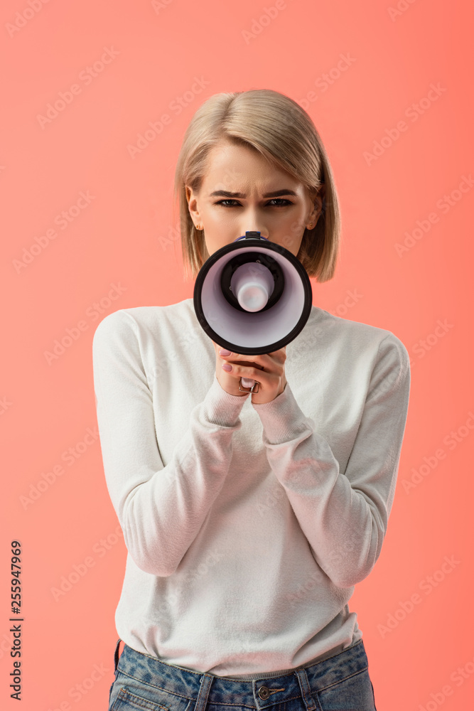Fototapeta premium blonde young woman speaking in megaphone isolated on pink