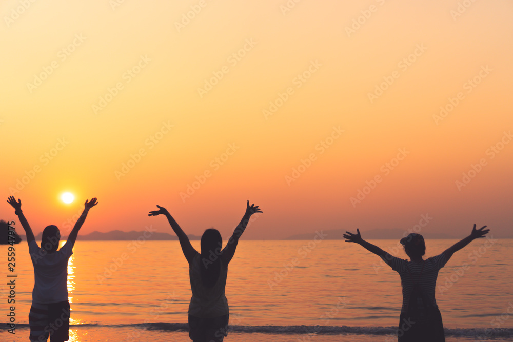 A group of womans rise hands up to sky freedom concept with blue sky and beach background.
