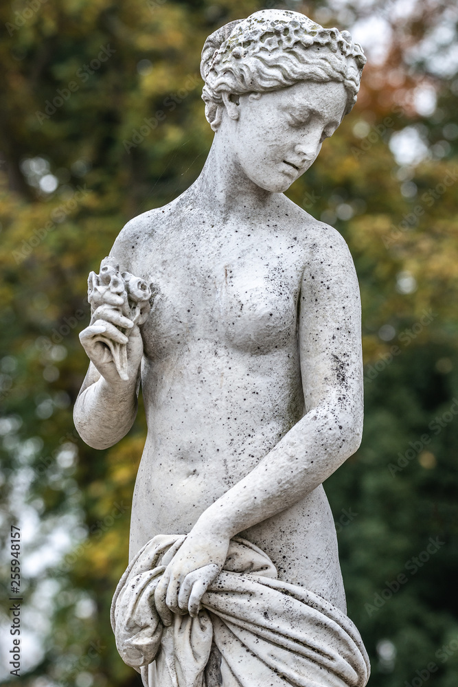 Statue of sensual naked Greek renaissance era woman with flowers, Potsdam, Germany, details, closeup