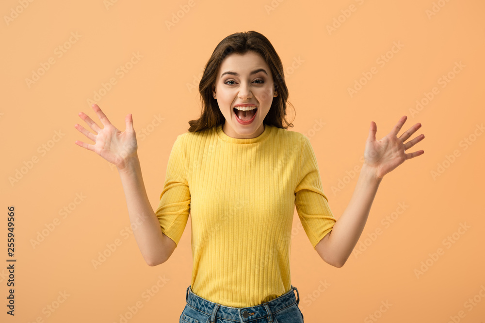 shocked young woman screaming while standing isolated on orange shocked young woman screaming while standing isolated on orange