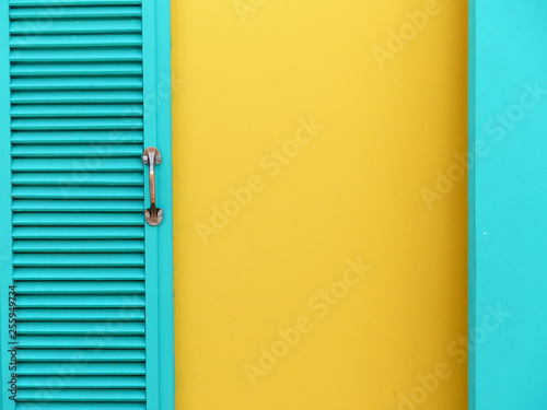 blue wood window on yellow wall