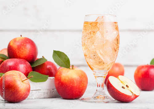 Glass of homemade organic apple cider with fresh apples in box on wooden background. Space for text